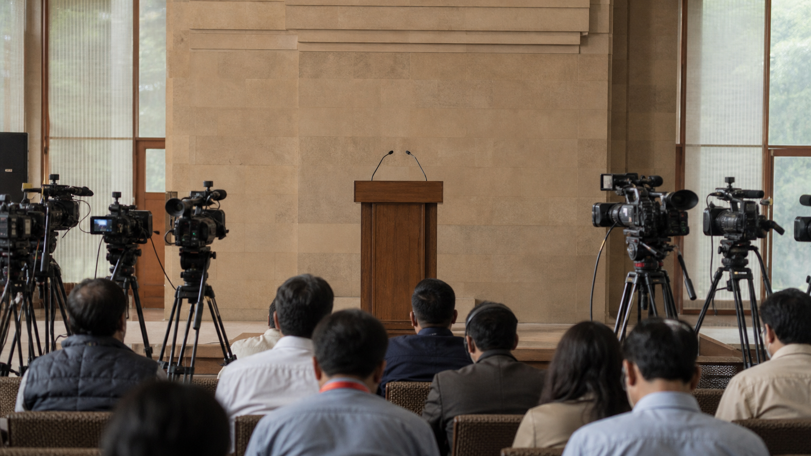 News cameras face an unbranded lectern in an Indian government briefing room before a national-security statement.
