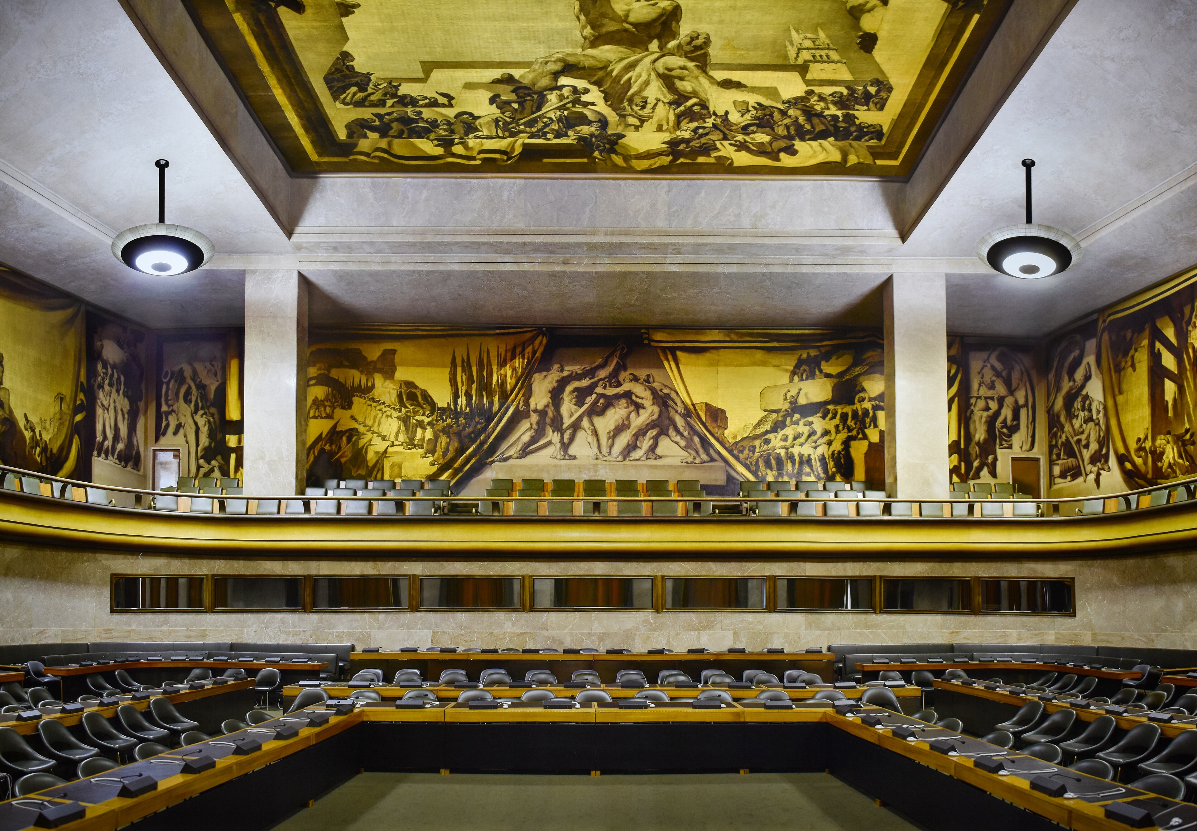 The United Nations council chamber in Geneva stands ready with curved rows of delegate seats.