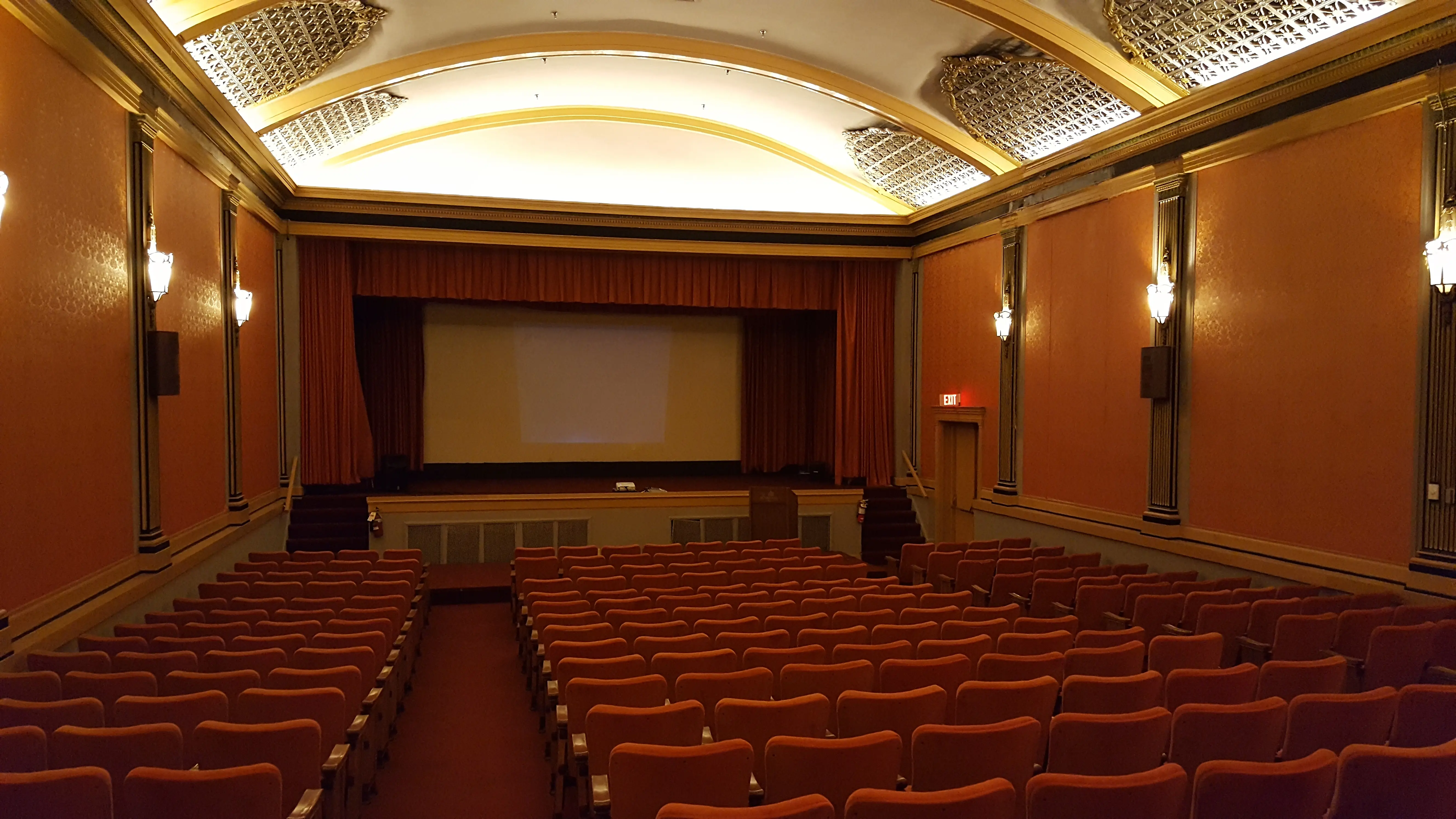 Historic cinema auditorium with rows of seats and a projection screen