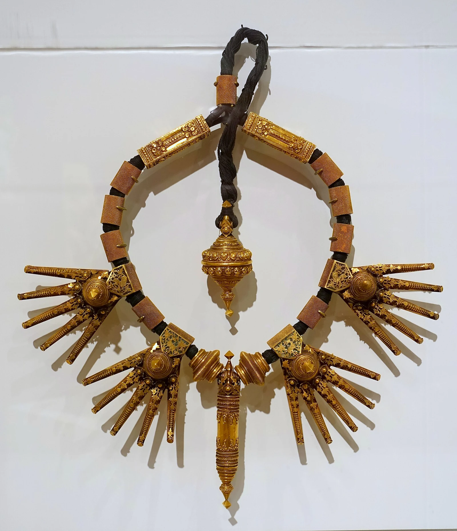 Ornate gold marriage necklace from Tamil Nadu displayed against a white background.